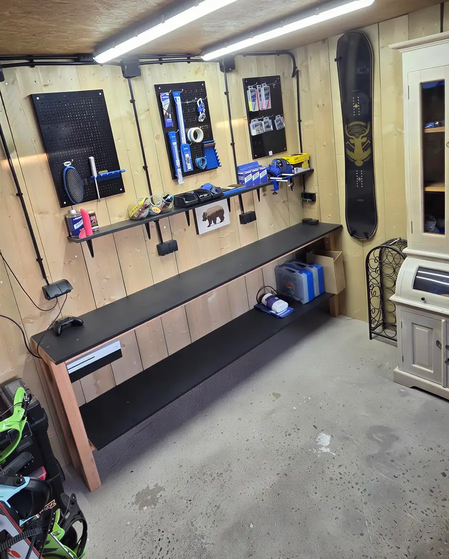 De werkplaats van Wakz: werkbank, gereedschap aan de wand en een snowboard